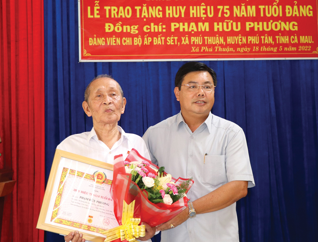 Đồng chí Nguyễn Tiến Hải - Ủy viên Trung ương Đảng, Bí thư Tỉnh ủy, Chủ tịch HĐND tỉnh Cà Mau trao Huy hiệu 75 năm tuổi đảng cho đảng viên Phạm Hữu Phương.